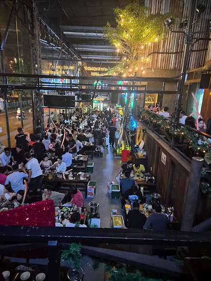 “Massive Vietnamese beer hall with DJ and long banquet tables.”